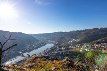 View over the Moselle at sunrise in a winter landscape. The castle and town of Cochem rise on the...