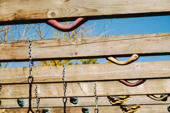 Close up of Various Holds, Chains, and Ropes on a Climbing Structure.