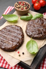 Delicious hamburger patties, tomatoes and spices on table, closeup