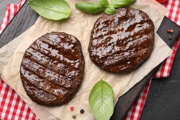 Delicious hamburger patties and spices on black table, top view