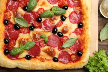 Tasty homemade pizza on wooden table, top view