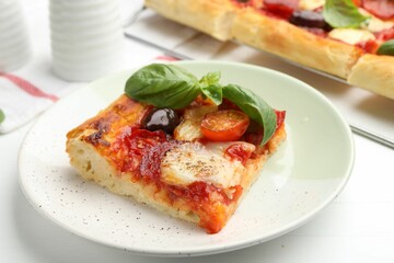 Piece of tasty homemade pizza on white wooden table, closeup