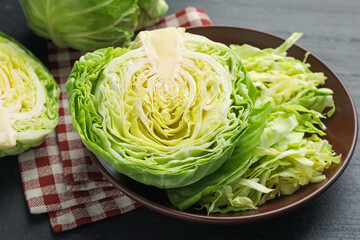 Cut fresh green cabbage on black table, closeup
