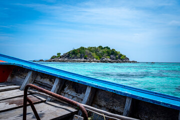 View of a Tropical Island in Clear Blue Waters from a boat in Thailand