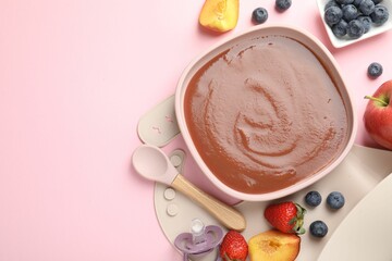 Baby food. Tasty puree in bowl, spoon and ingredients on pink table, flat lay. Space for text