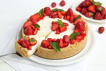 Delicious cheesecake with strawberries and mint on white wooden table, above view