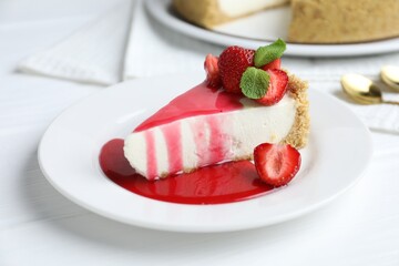 Piece of tasty cheesecake with strawberries, sauce and mint on white wooden table, closeup