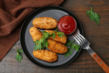 Tasty fried croquettes, parsley and sauce on wooden table, flat lay
