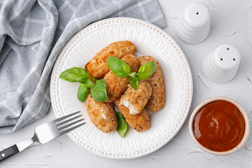 Tasty fried croquettes, basil and sauce on white textured table, flat lay