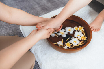 Woman indulges in blissful foot massage at luxurious spa salon while masseur give reflexology therapy in gentle day light ambiance resort or hotel foot spa. Quiescent
