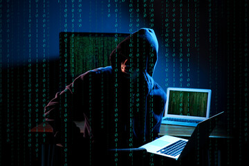 Cyber attack. Hacker working on computers in dark room. Binary code around him