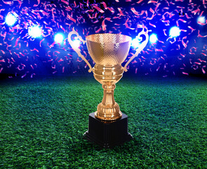 Football championship. Shiny golden trophy cup under falling confetti on illuminated stadium