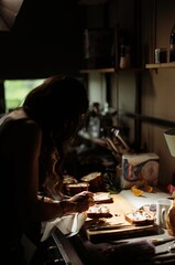 A dedicated pastry chef skillfully decorates cozonac with colorful ingredients in a warm kitchen