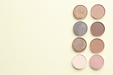 Beautiful eyeshadow refill pans on beige background, flat lay. Space for text