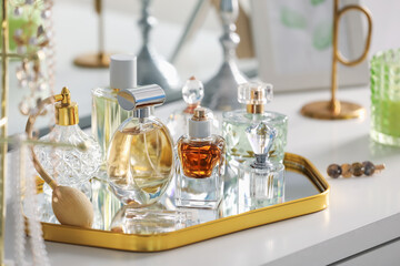 Bottles of different perfumes on white table indoors, closeup