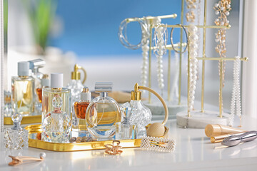 Bottles of different perfumes and accessories on table indoors