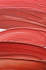 Colorful lip glosses as background, top view