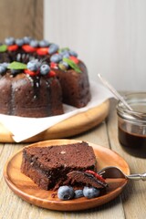 Delicious chocolate bundt cake with blueberries on wooden table, closeup