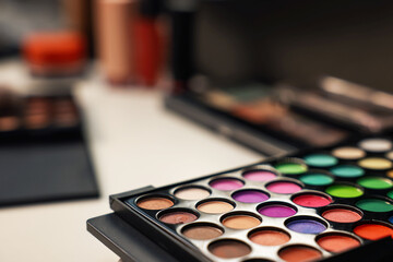 Colorful eyeshadow palette on dressing table, closeup