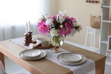 Beautiful table setting with bouquet of peonies in dining room