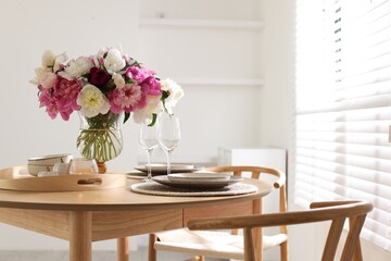 Beautiful table setting with bouquet of peonies in dining room. Space for text