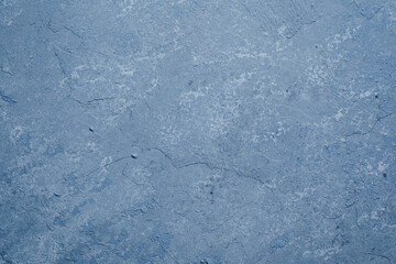 Grunge blue plaster wall with weathered texture and mottled pattern