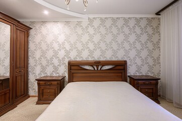 bedroom featuring a classic wooden bed, matching nightstands, and a wardrobe. The walls are adorned...