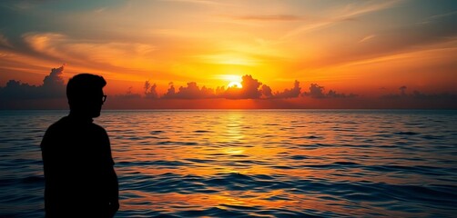 Fototapeta premium Silhouette against vibrant sunset over calm ocean, horizon, shoreline
