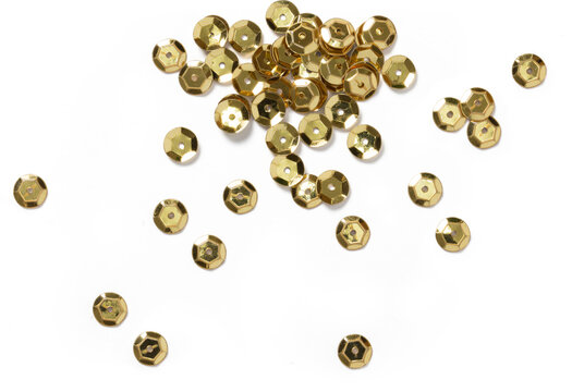 A collection of shiny gold sequins scattered across a surface, ideal for crafting and decorative purposes.
