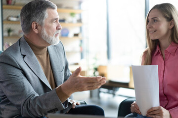 Two colleagues of the company, woman and mature man, working together on a new project in modern...