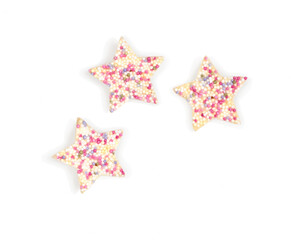 Three star-shaped cookies decorated with colorful sprinkles, perfect for celebrations and festive occasions.
