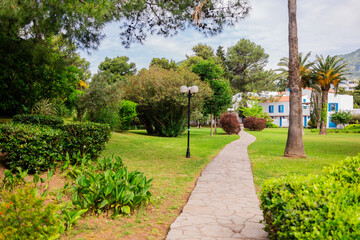 Serene garden path in a summer hotel resort. Greenery, palm trees and peaceful holiday atmosphere...