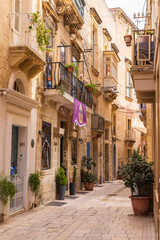 Obraz premium Malta, Birgu. Narrow street with stone buildings.
