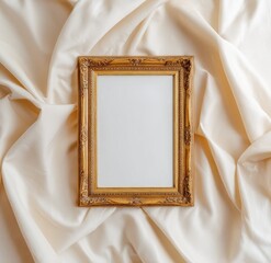 Ornate gold frame rests on creamy, draped fabric; blank interior; overhead shot