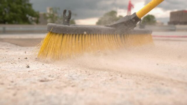 Push broom sweeping through construction site slow motion
