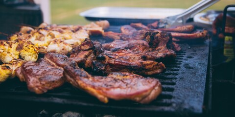 Delicious grilled meats sizzle on a hot charcoal barbecue, ready for a summer feast.