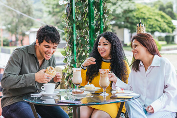 Three people are sitting at a table, enjoying a meal together