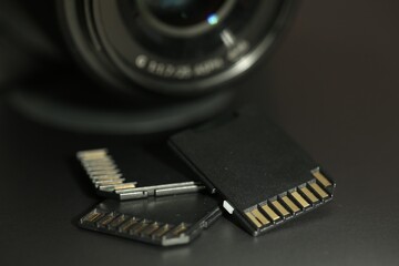 SD memory cards and photo camera on laptop, closeup