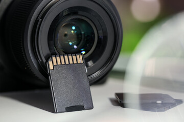 SD memory cards and photo camera on white table, closeup