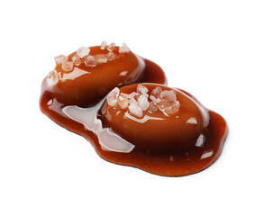 Tasty sweet candies, salt and caramel sauce isolated on white