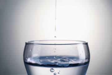 Fresh water in glass on gray gradient background, closeup