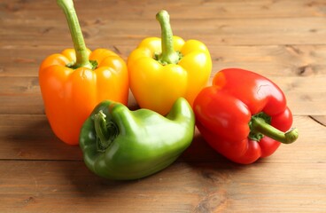 Ripe colorful bell peppers on wooden table, closeup