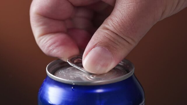 Human hand open aluminum beverage can. Drink in metal jar closeup. Opening soda can