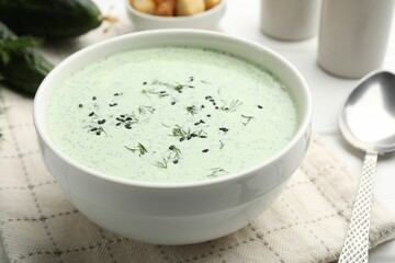 Tasty cucumber soup served on white table, closeup