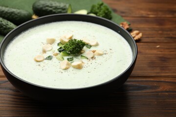 Tasty cucumber soup with croutons and broccoli on wooden table, closeup