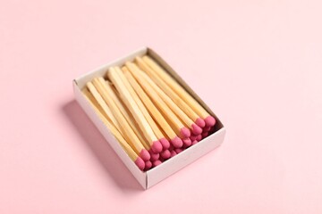 Matches in box on pink background, closeup