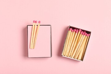 Matches and box on pink background, flat lay