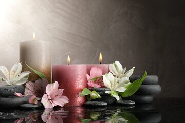 Burning candles, spa stones and beautiful flowers on wet black table. Space for text