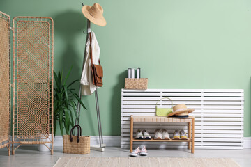 Different footwear, clothes and accessories in hallway