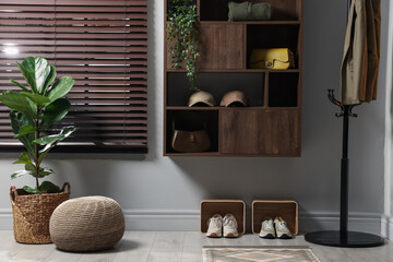 Shelving unit with different accessories and shoes in hallway